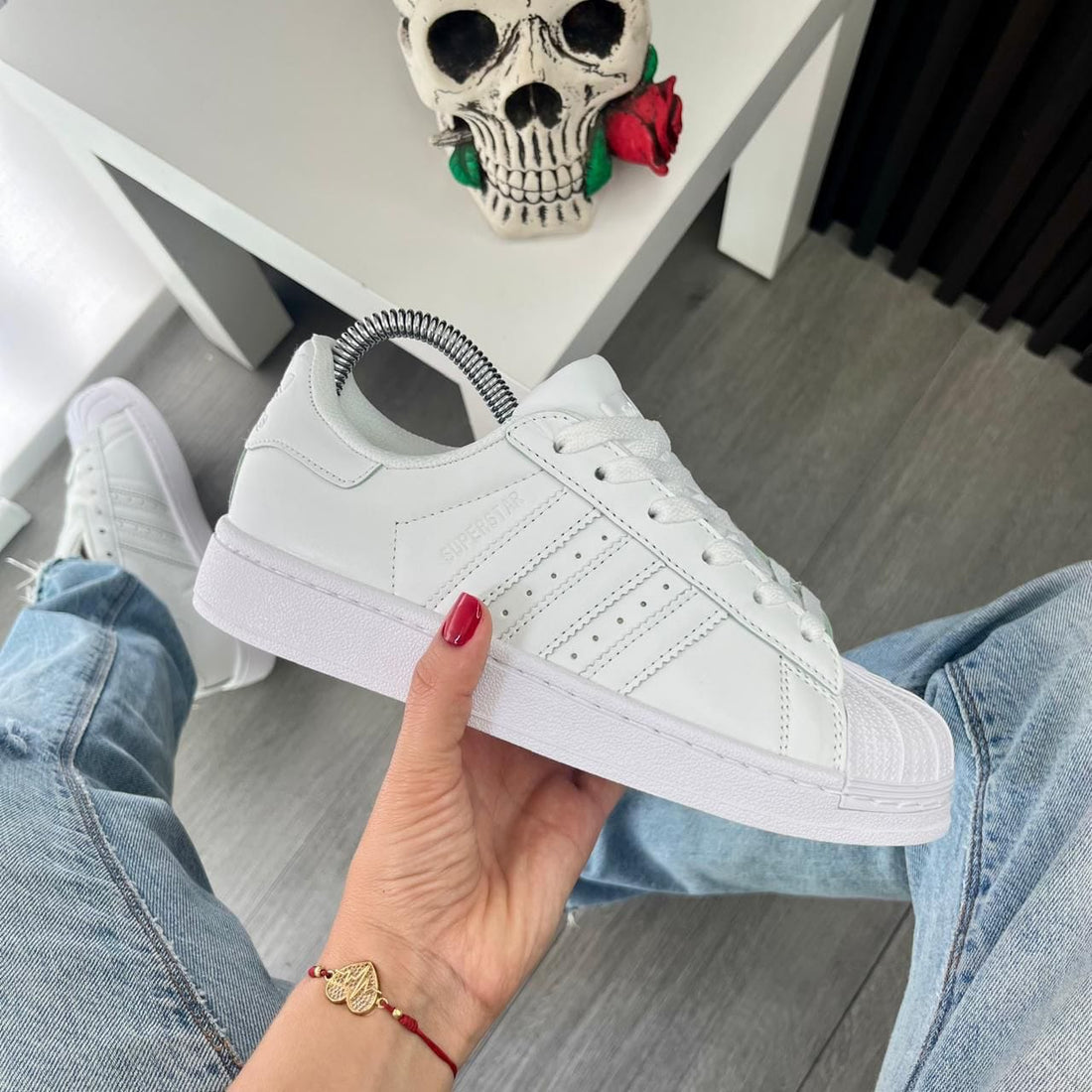 Tenis Adidas estilo Superstar blancos con franjas laterales blancas.